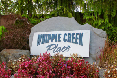Whipple Creek Place community entrance sign with pink flowers